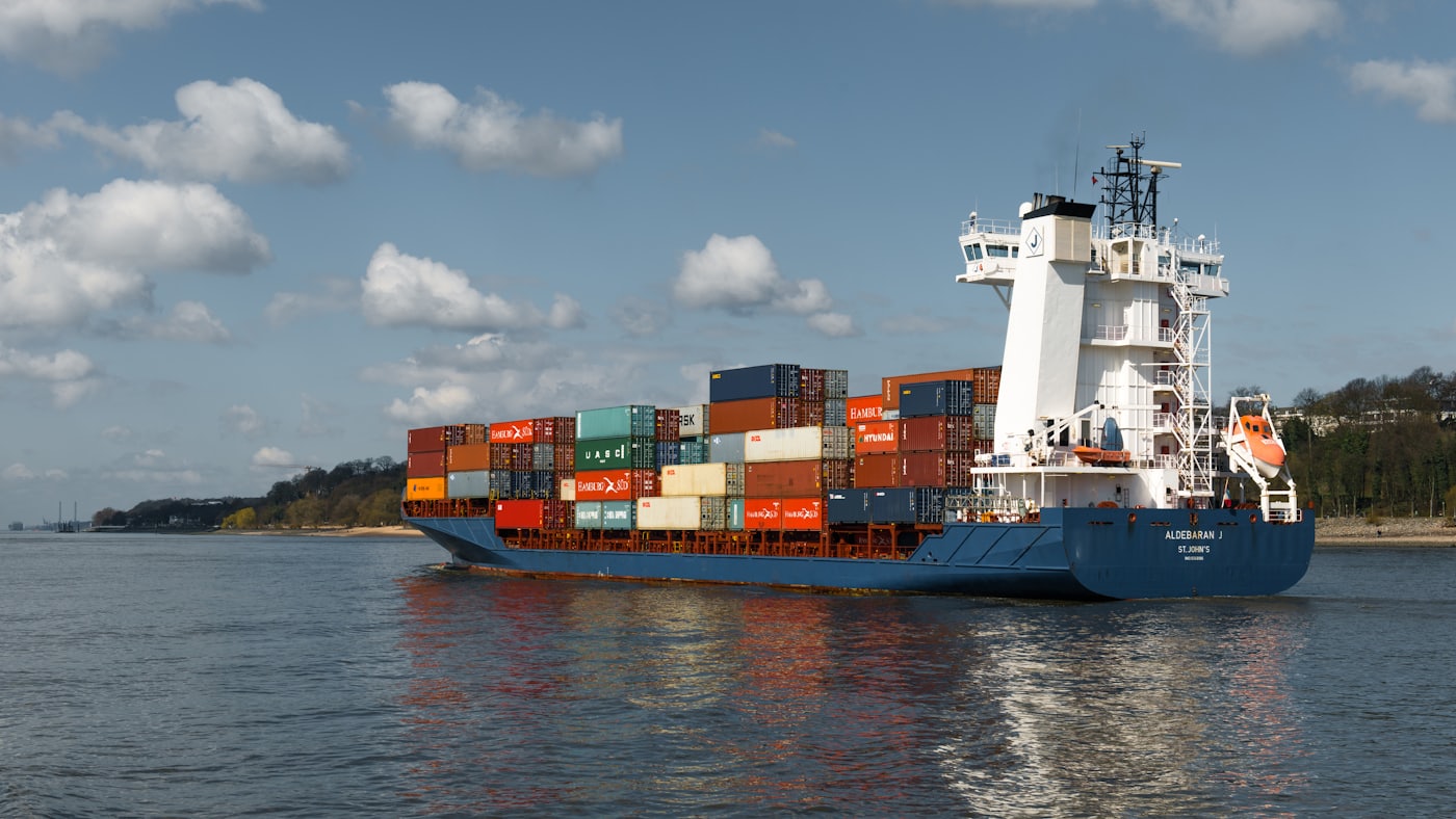Een groot schip vaart door een smalle vaargeul